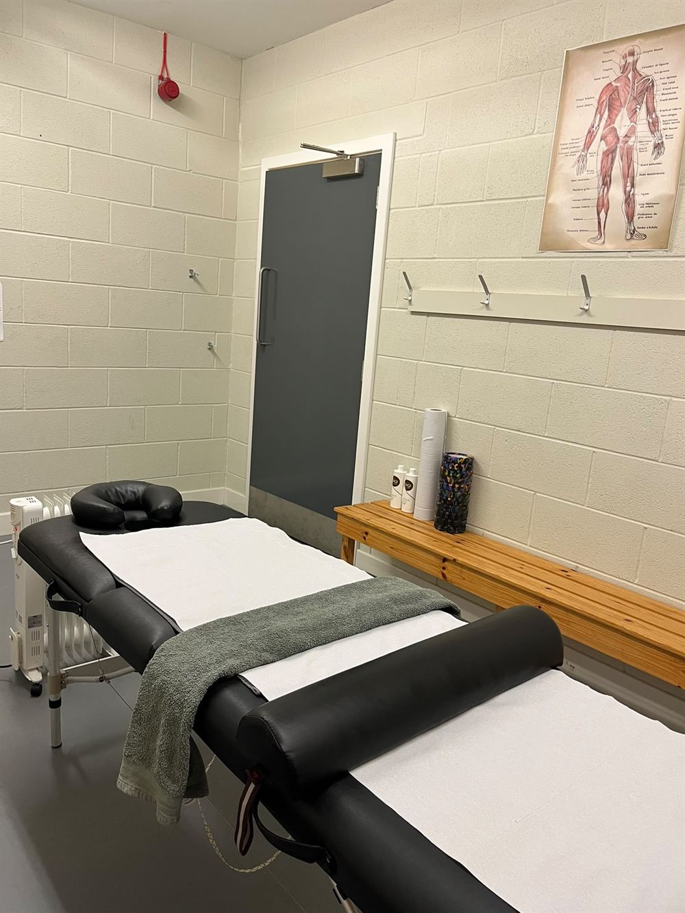 The treatment room at Cove Youth FC Pavilion, with massage table and anatomy chart